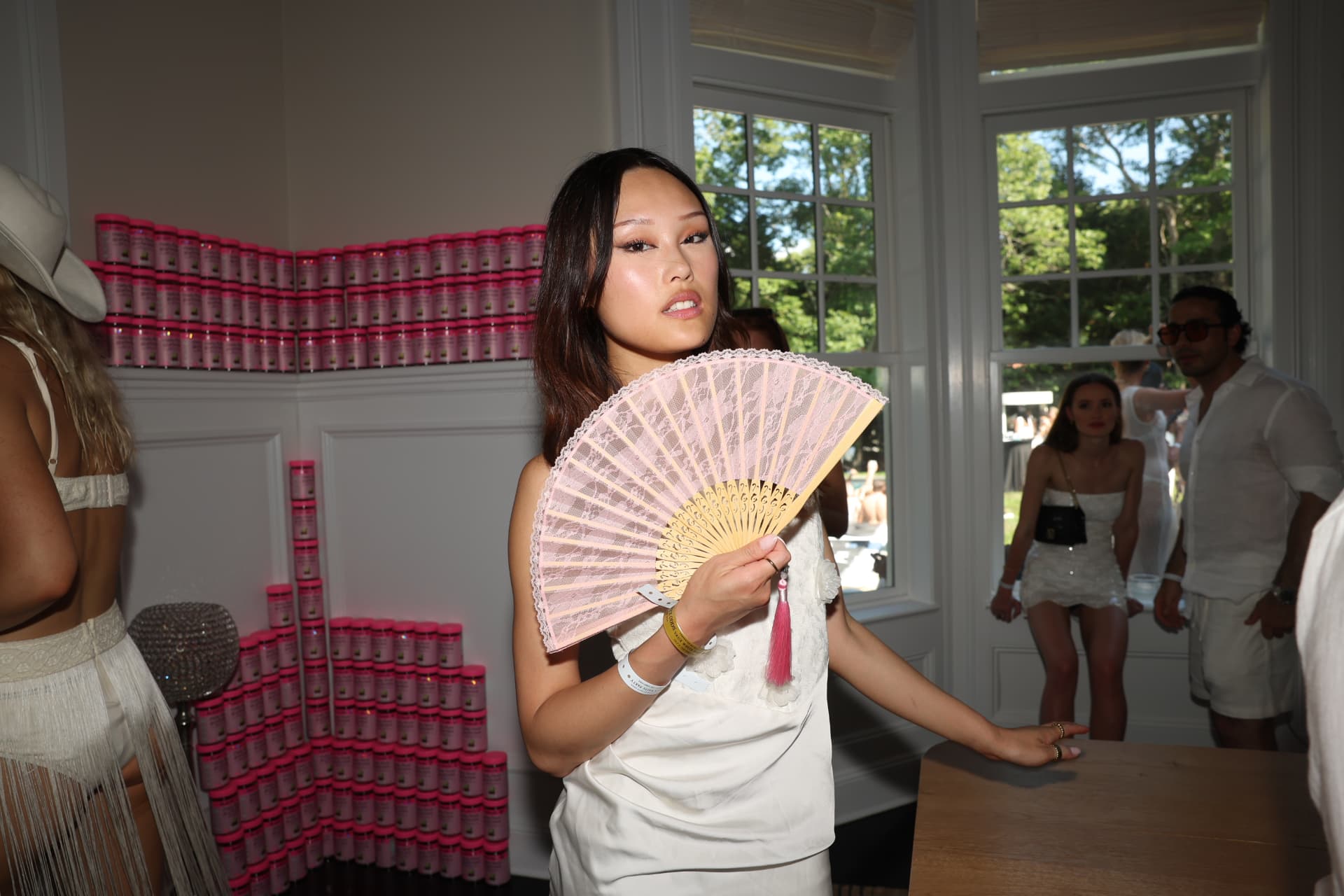 Guest with a lace fan beside a sponsor activation